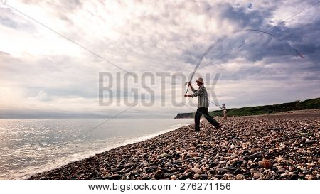 Taiwan, Hualien, Qixingtan Beach, May 2013: An Unidentified Man Casts His Fishing Rod Into The Ocean