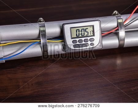 Pipe Bomb With An Clock Timer To Trigger Detonation, On Wooden Table