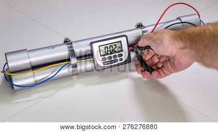 Hand Cutting Wire On Pipe Bomb On White Background