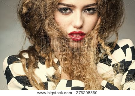 Portrait Of Attractive Radiant Looking Blond Young Woman With Fly-away Wavy Long Hair Wearing Black 