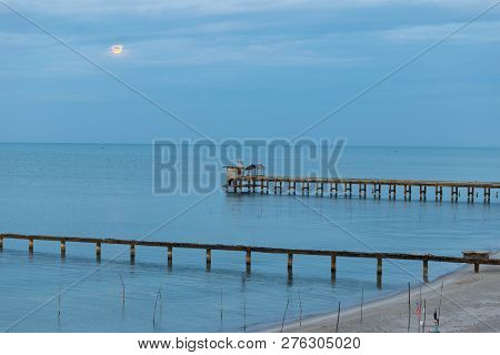Beach, Bridge And The Moon Is Rising At 
Nim Seng Beach, Songkhla, Thailand.