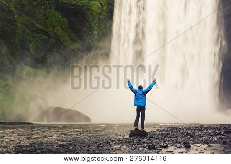 Single Man Standing Near Scogafoss Waterfall In Iceland And Spread His Hands. Travel Summer Nordic C