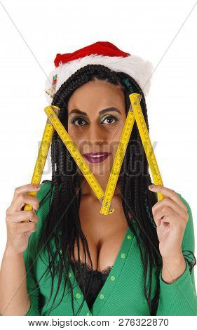 A Young Woman In A Green Body Suit And Santa Hat Holding A Wooden
Zollstock, Ruler, Over Her Face, I
