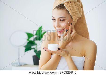 Spa. Beautiful Model Applying Cosmetic Cream Treatmen On Her Face