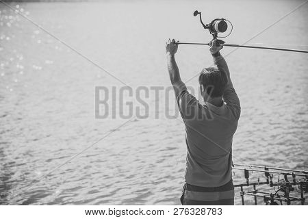 Adventure, Sport, Activity. Fisherman Cast Fishing Rod In Lake Or River Water. Man Fish With Spinnin