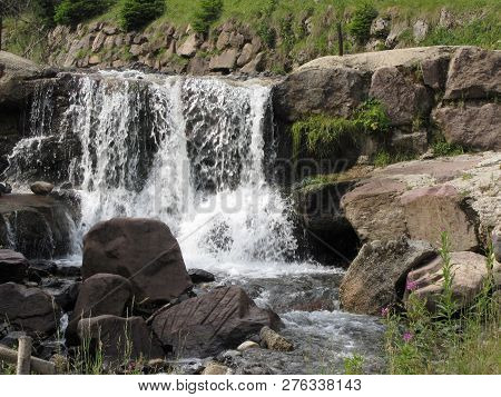 Water Flowing And Splashing Over Rocks In A Mountain River Stream