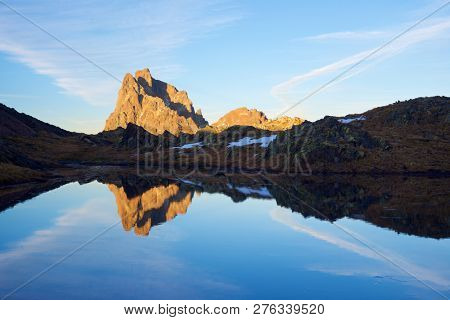Midi Dossau Peak reflected in a lake. Ossau Valley, Pyrenees National Park, Pyrenees, France.