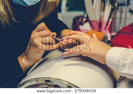 Manicurist Applying Red Nail Varnish. Manicure Master Painting Female Finger With Close Up. Manicure