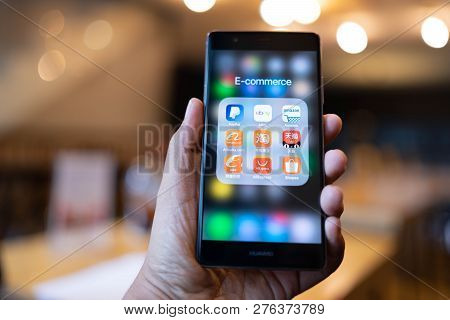 Chiang Mai, Thailand - June 03,2018: Man Holding Huawei With Icons Of E-commerce And Online Shopping