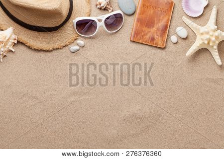Travel vacation background concept with sunglasses and hat on sand backdrop. Top view with copy space. Flat lay