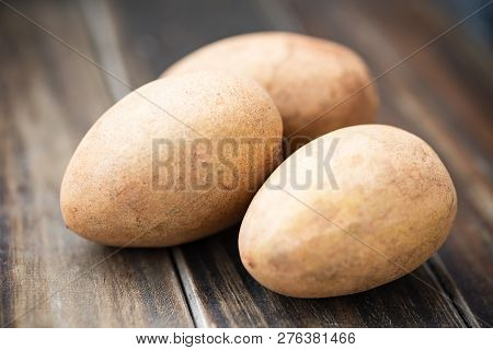 Sapodilla Plum Fruit On Wooden Table, Exotic Thai Fruit (la Mood)