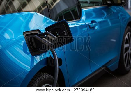 Power supply for electric car charging. Electric car charging station. Close up of the power supply plugged into an electric car being charged.
