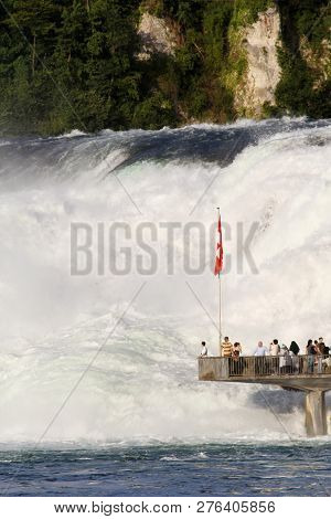 Neuhausen, Switzerland - July 18, 215: Visitors Are Watching The Powerful Torrent At The Rhinefall P