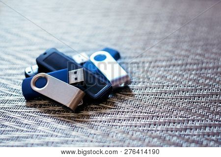 Many Usb Flashes On Metallic Textural Background. Heap Of Plastic Flash Drives On Metallic Texture