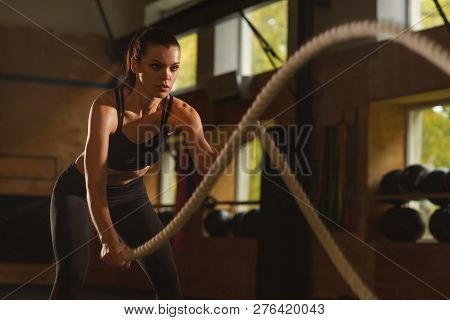 Fit, Sporty And Athletic Sportswoman Working In A Gym. Woman Training Using Battle Ropes. Sports, At