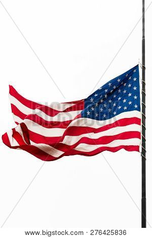 United States Flag Flying At A Half-staff Waving Against Gray Sky