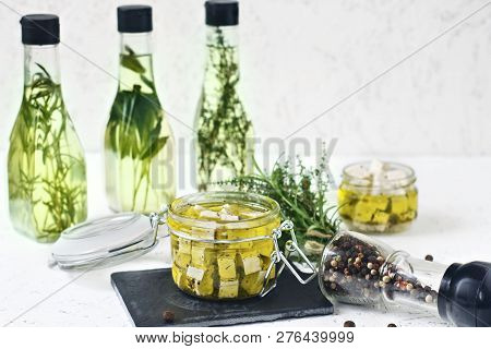 Marinated Feta In A Glass Jar, Spices And Flavored Olive Oil On A Wooden Background