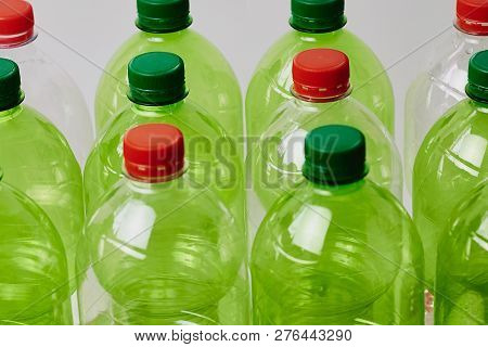 Many Green Plastic Bottles With Caps. Production Of Beverages In Plastic Containers. Problem Of Envi