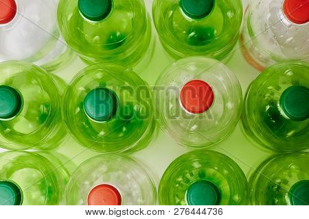 Many Green Plastic Bottles With Caps. Production Of Beverages In Plastic Containers. Problem Of Envi