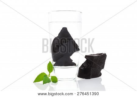 Purifying Water With Shungite Stones. Glass Of Water With Shungite Stones Isolated On White. Removin