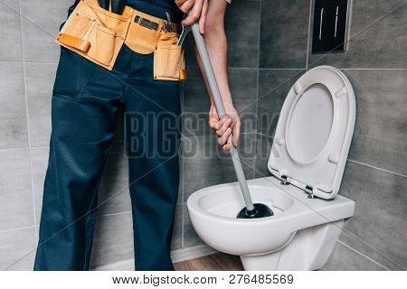 Partial View Of Male Plumber Using Plunger And Cleaning Toilet In Bathroom
