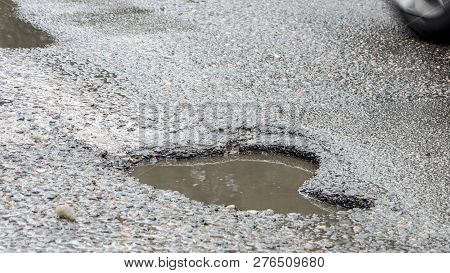 There Are Many Potholes On The Roadway Close Up