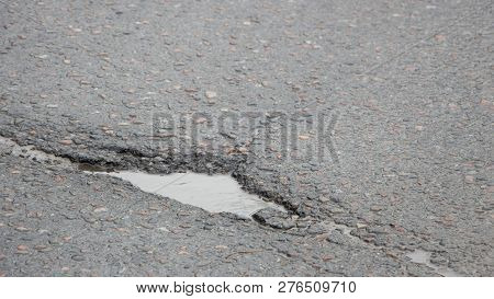 There Are Many Potholes On The Roadway Close Up