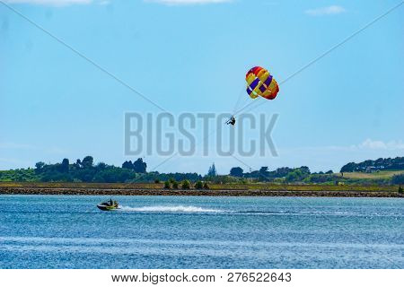 Tauranga, New Zealand December 22 2018; Summer Fun Being Towed Over The Bay While Hanging Under A Pa