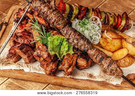 The Concept Of Georgian Cuisine. Meat Board With Shashlik, Grilled Pork Ribs, Lulya Kebab And Shish 