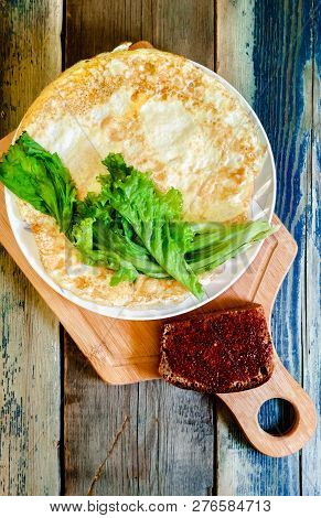 Fried Egg In The Form Of A Pancake, Wooden Cutting Board. Breakfast, Still Life.