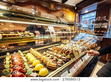 Strasbourg, France - Dec 29, 2018: Woman Pointing To Sweets In Traditional French Pastry Store, Riss