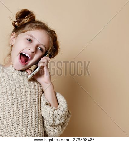 Little Girl In Oversized Sweater Happily Chatting On By Cell Phone With His Classmates Nude Beige Ba