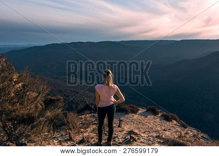 Female  Enjoying All The Mountain Wilderness Beauty. Feeling The Breeze As It Rushes Through The Val