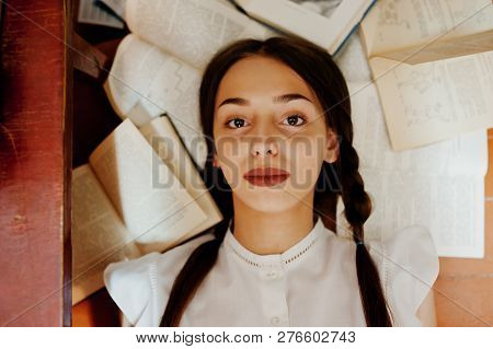 Girl With Pigtails In White Blouse At Old Library.
