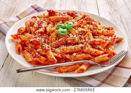 Close-up Of A Portion Of Classic Italian Penne Arrabiata With Basil And Freshly Grated Peccorino Che