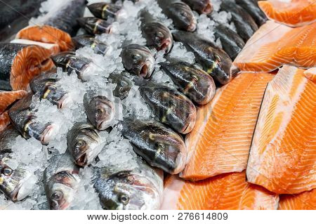 Fresh Seafood On Crushed Ice At Fish Market. Raw Dorado, Seabass And Salmon Fillet On Display Counte