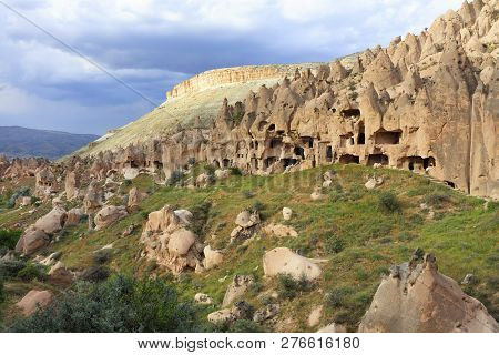 Quarter Of Old Antique Residential Caves On The Background Of The Conical Ridges Of Cappadocia And T