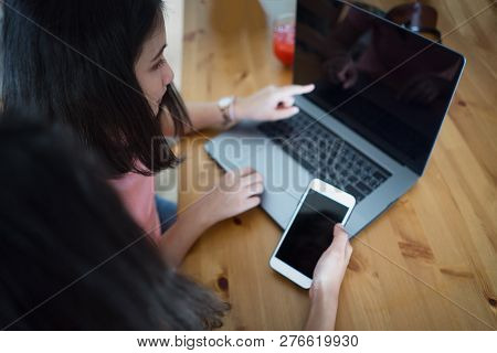Young Business Women Compering Laptop And Smartphone Display, Mockup.
People Working Together On Not