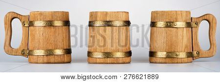 Three Oak Mugs For Beer Stand On A Gray Background
