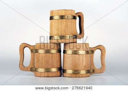 Three Oak Mugs For Beer Stand On A Gray Background