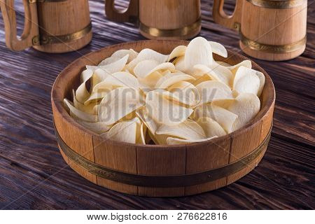 Potato Chips Lie In A Light Oak Tray On A Dark Table.