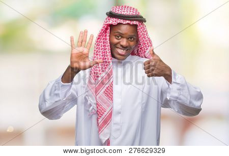 Young arabic african man wearing traditional keffiyeh over isolated background showing and pointing up with fingers number six while smiling confident and happy.