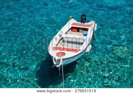 White Boat At Crystal Clear Blue Water Of Marmara Beach, Near Aradena Gorge, Island Of Crete, Greece