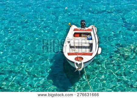 White Boat At Crystal Clear Blue Water Of Marmara Beach, Near Aradena Gorge, Island Of Crete, Greece