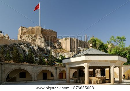 URFA, TURKEY - AUGUST 19, 2008: Turkish flag over the citadel of Urfa viewed from the court of Yeni Dergah Mosque. This ancient ruined castle has newer walls dating from around 814 AD