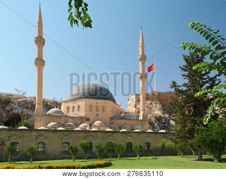 URFA, TURKEY - AUGUST 19, 2008: Yeni Dergah Mosque and Turkish flag over the citadel of Urfa. This ancient ruined castle has newer walls dating from around 814 AD