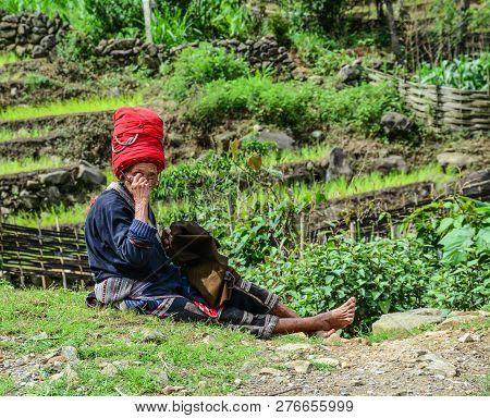 Sa Pa, Vietnam - May 31, 2016. An Old Woman Sewing On Rural Road In Sa Pa, Vietnam. Sa Pa Is A Mount