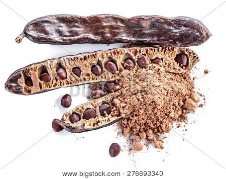 Carob pods and carob powder on the white background.