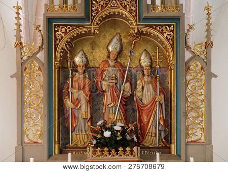 PETSCHIED, ITALY - JULY 14, 2018:Saint Martin, Nicholas and Sylvester, statues on the main altar in the Saint Nicholas church in Petschied near Luson, Italy