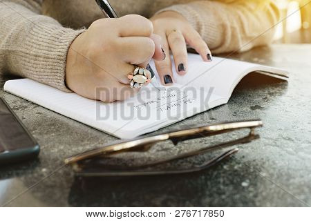 View Of Female Hands Writing Her Life Goals In A Journal